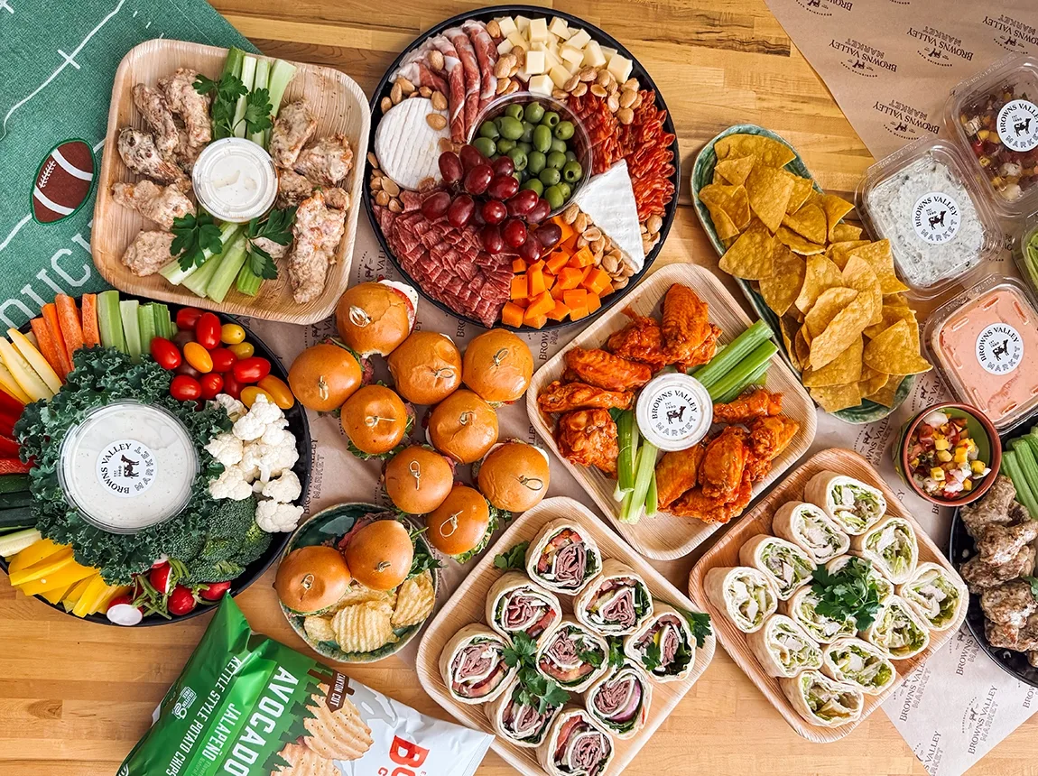 An overhead view of a Super Bowl party spread of foods, appetizers, and finger foods from Browns Valley Market in Napa